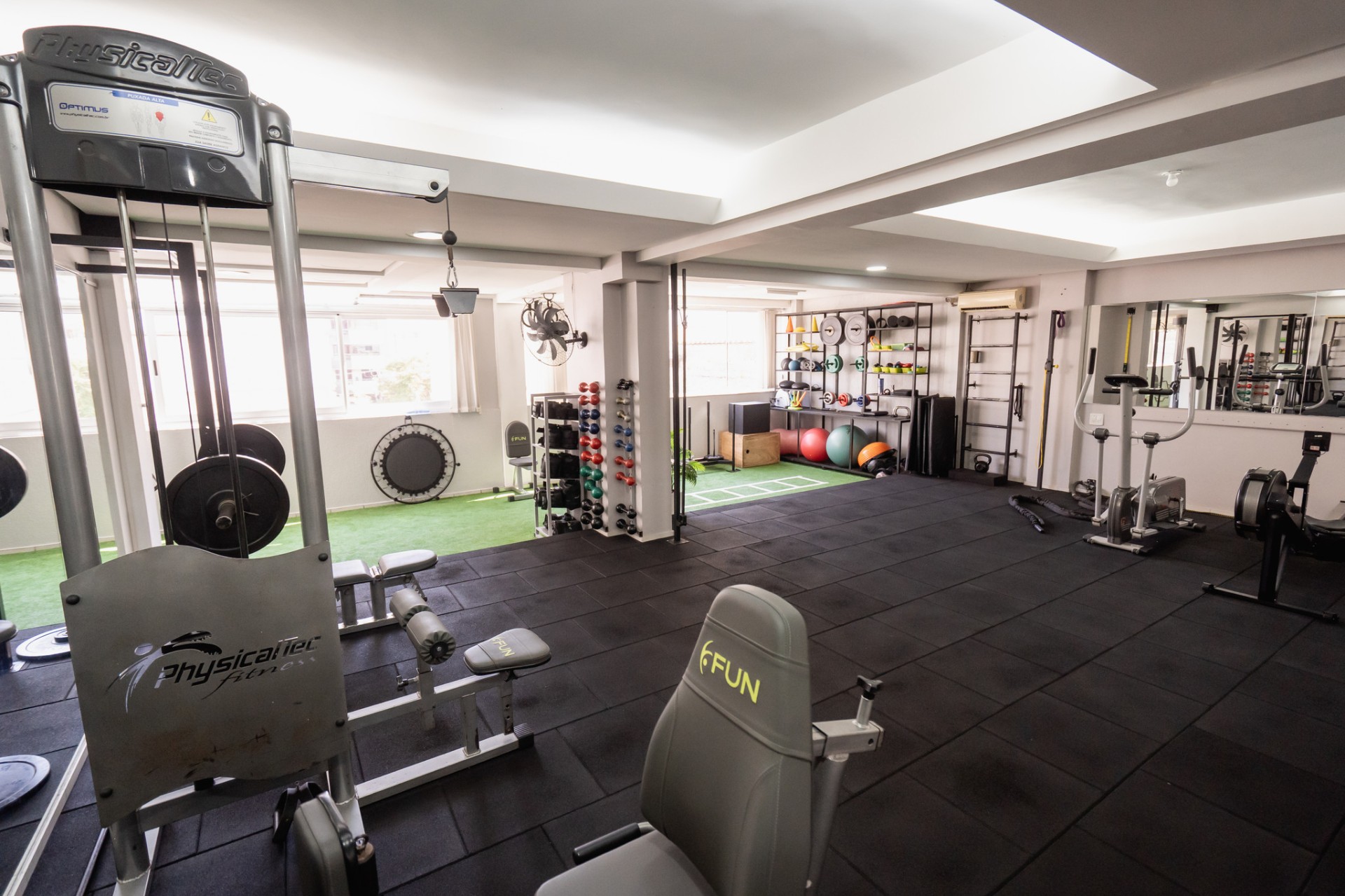 Vista da sala de treino, com luz natural e equipamentos